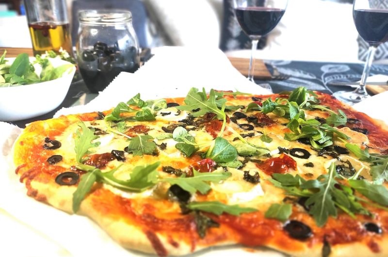 Masa de pizza casera, pizza de queso de cabra y tomates confitados.