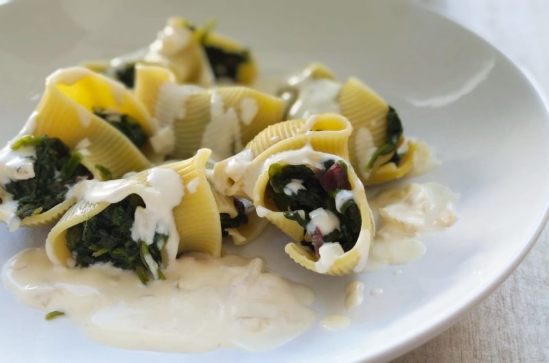 Caracolas de pasta rellenas de espinacas y suave salsa de queso